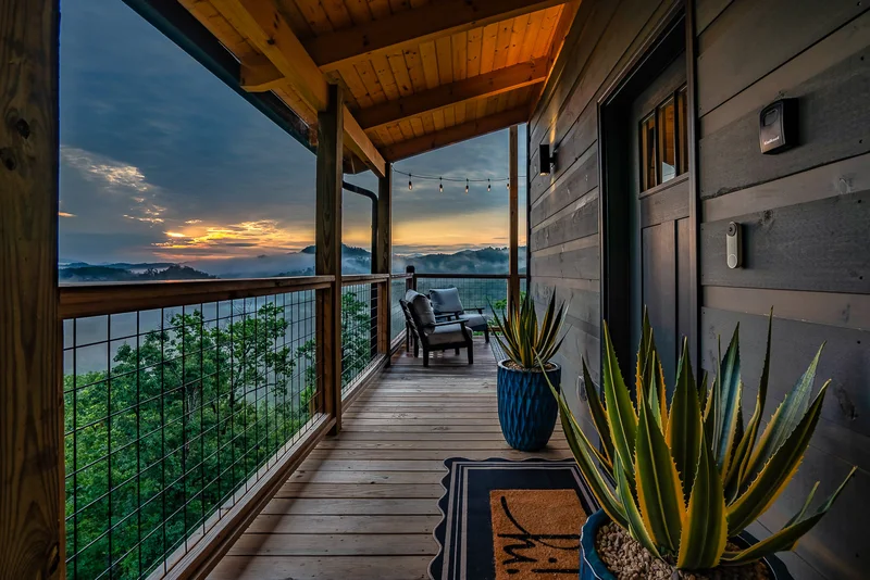 Covered porch walkway with potted plants and mountain view