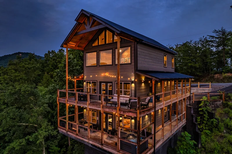Cabin exterior with multiple decks above a wooded hillside