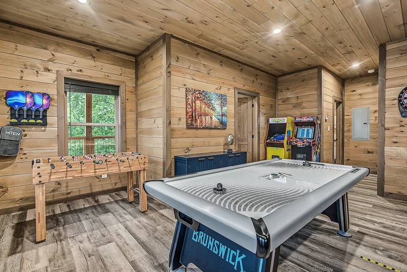 Game room with foosball table, air hockey table, and arcade machines