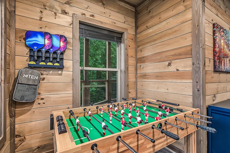 Foosball table with pickleball paddles mounted on the wall