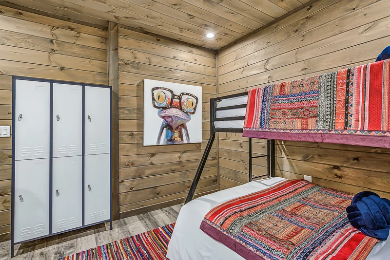 Bunk bed beside white lockers and playful wall artwork