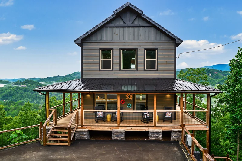 Front view of cabin with covered porch and mountain landscape