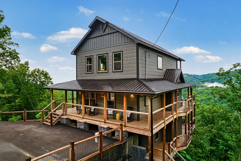 Cabin exterior viewed from the side with layered decks and trees