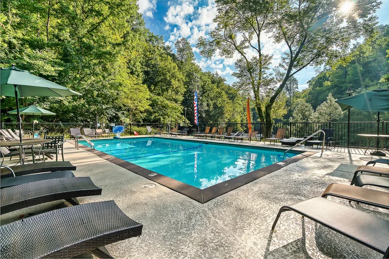 Outdoor swimming pool surrounded by lounge chairs and umbrellas