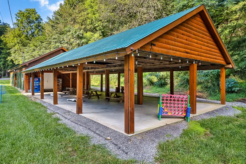 Fenced grassy dog park with a small shade shelter
